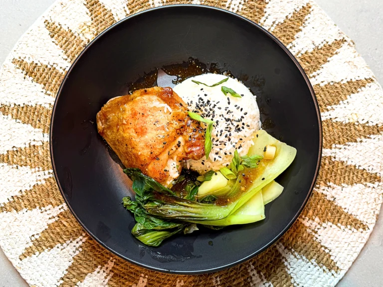 Crispy-skin Filipino-style chicken teriyaki cooked in a Toyomansi glaze made of soy sauce and calamansi, served with lemon-kissed pak choy and steamed rice on a plate