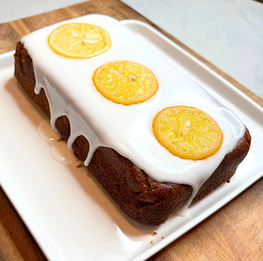 Lemon poppy seed loaf cake with lemon glaze and candied lemon slices, fresh homemade citrus dessert.