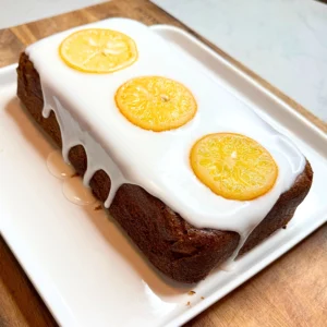 Lemon poppy seed loaf cake with lemon glaze and candied lemon slices, fresh homemade citrus dessert.
