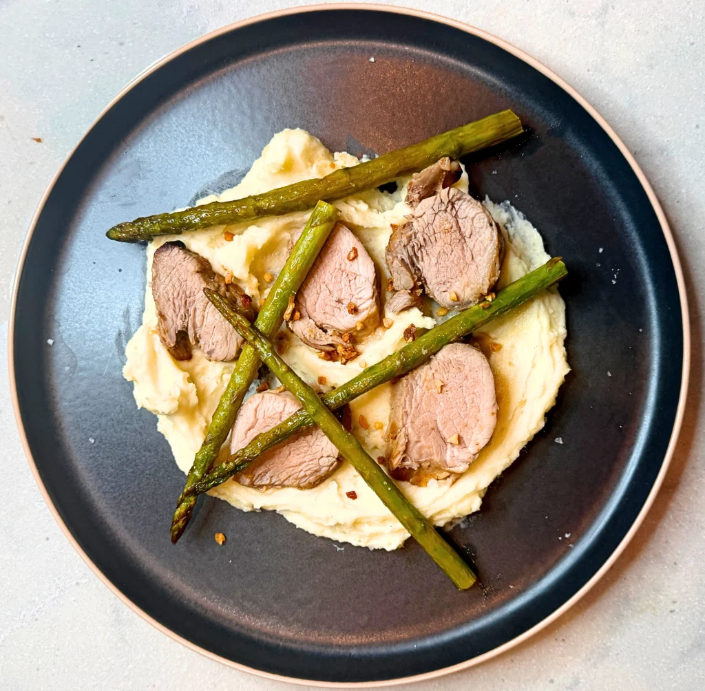 Filipino-inspired sticky pork fillet with mashed potato, asparagus and crispy garlic.